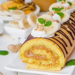 Najprostsza rolada biszkoptowa z kremem orzechowym i bananami, udekorowana czekoladą i miętą.