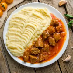 Gulasz wieprzowy z puree ziemniaczanym, idealne połączenie smaków. Jakie przyprawy do gulaszu wieprzowego? Papryka, majeranek, czosnek.