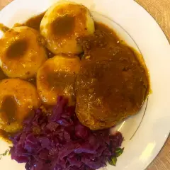 Kotlet schabowy w sosie z szynki wieprzowej, podany z kluskami śląskimi i czerwoną kapustą. Pyszny obiad!