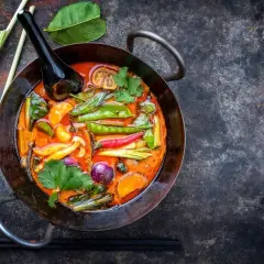 Kolorowe warzywa do curry: groszek cukrowy, papryczki chili, cebula, marchewka i trawa cytrynowa w aromatycznym sosie.