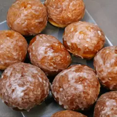 Szybkie pączki z piekarnika, oblane lukrem, kuszą swoim apetycznym wyglądem. Idealne na szybką przekąskę.