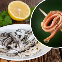 Na talerzu marynowane **anszua** z cytryną i natką. Obok, na wykałaczce, zwinięty filet.