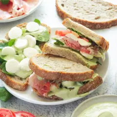 Pyszne włoskie kanapki z mozzarellą, szynką parmeńską i zielonym sosem na chrupiącym pieczywie.