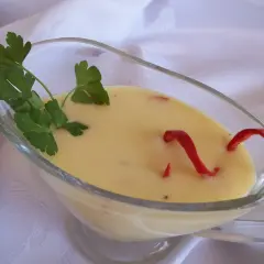 Kremowy sos cytrynowy do ryby, ozdobiony natką pietruszki i papryczką chili.