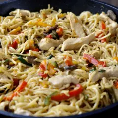 Kurczak po chińsku z mieszanką chińską, podany w woku, z makaronem, papryką, cukinią i grzybami.