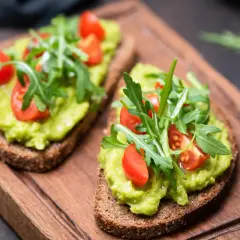 Pyszny tost z pastą z awokado, pomidorkami koktajlowymi i rukolą. Idealny przepis na szybkie śniadanie lub przekąskę.