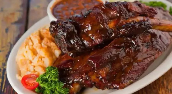Soczyste żeberka w sosie BBQ, podane z puree ziemniaczanym i fasolką. Idealna marynata do żeberek sprawia, że mięso jest kruche i aromatyczne.