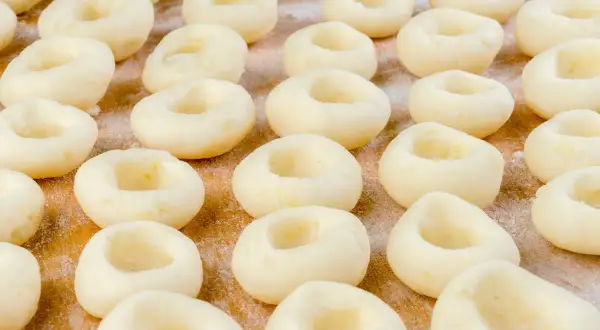 Rządki okrągłych klusek śląskich, idealnych na obiad. Zastanawiasz się, ile kcal ma kluska śląska?