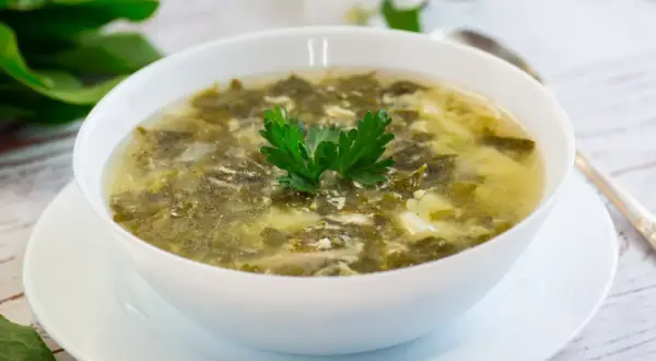 Zupa szczawiowa ze słoika przepis: aromatyczna, zielona zupa z dodatkiem jajka, udekorowana natką pietruszki.