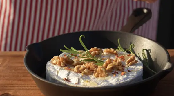 Ser camembert z orzechami i rozmarynem w żeliwnej patelni, idealna przystawka do grilla.