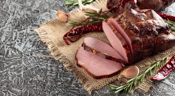 Wędzenie schabu: soczyste plastry na płótnie, ozdobione rozmarynem, czosnkiem i papryczkami chili.