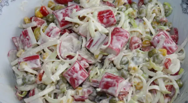 Pyszna sałatka z surimi, groszkiem, kukurydzą i porem, polana kremowym sosem. Idealna na każdą okazję!