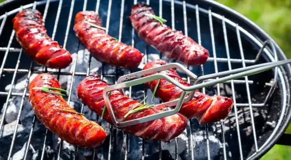 Aromatyczna kiełbasa z grilla, rumiana i skwiercząca, z gałązkami rozmarynu. Idealna na letnie spotkania.