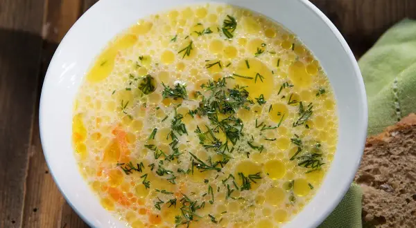 Aromaticzna ogórkowa z koperkiem, pływająca w złocistym bulionie, podana z chlebem.