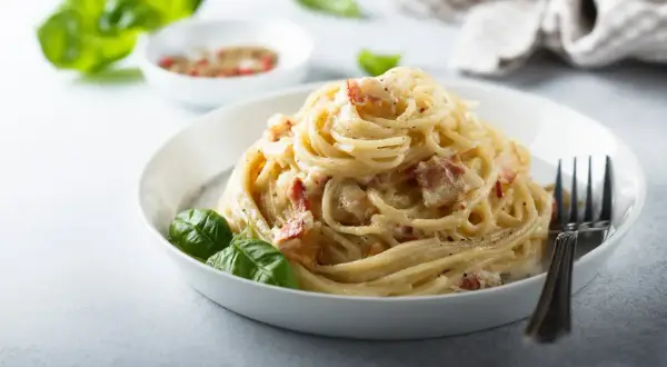 Pyszne spaghetti carbonara z boczkiem i bazylią. Idealne carbonara skladniki na szybki obiad.