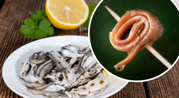 Na talerzu marynowane **anszua** z cytryną i natką. Obok, na wykałaczce, zwinięty filet.