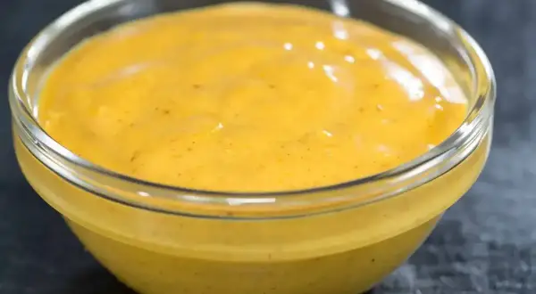 Gęsty, kremowy sos curry w szklanej miseczce, gotowy do podania z ulubionymi daniami.