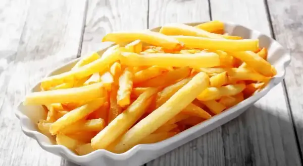 Złociste frytki w białej miseczce, wyglądają jak te z McDonald's. Chcesz wiedzieć jak zrobić frytki z McDonald's?