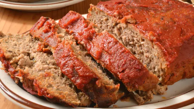 Kawałki pieczeni rzymskiej z sosem pomidorowym, jak z przepisu Siostry Angeli. Aromatyczne i soczyste danie.