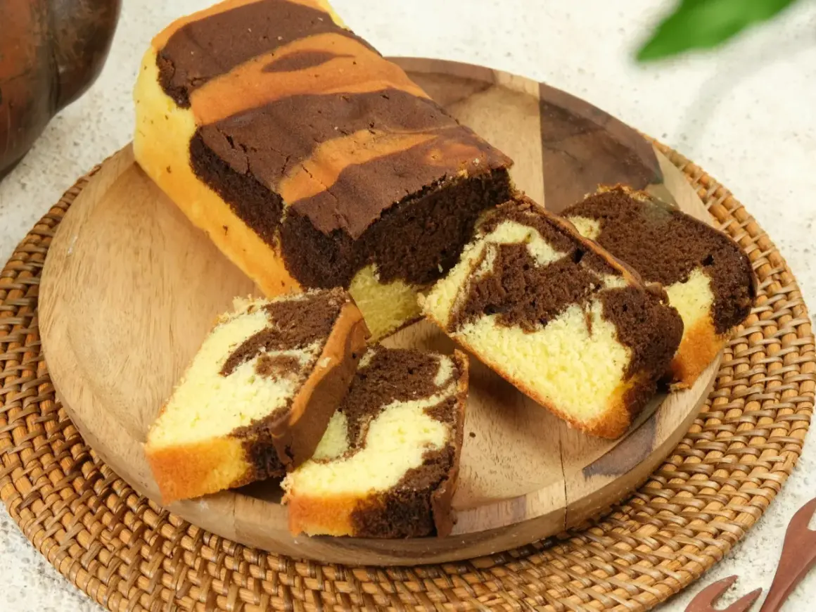 Pyszna babka marmurkowa która zawsze się udaje, pokrojona na kawałki, prezentuje swoje piękne, czekoladowo-waniliowe wzory.