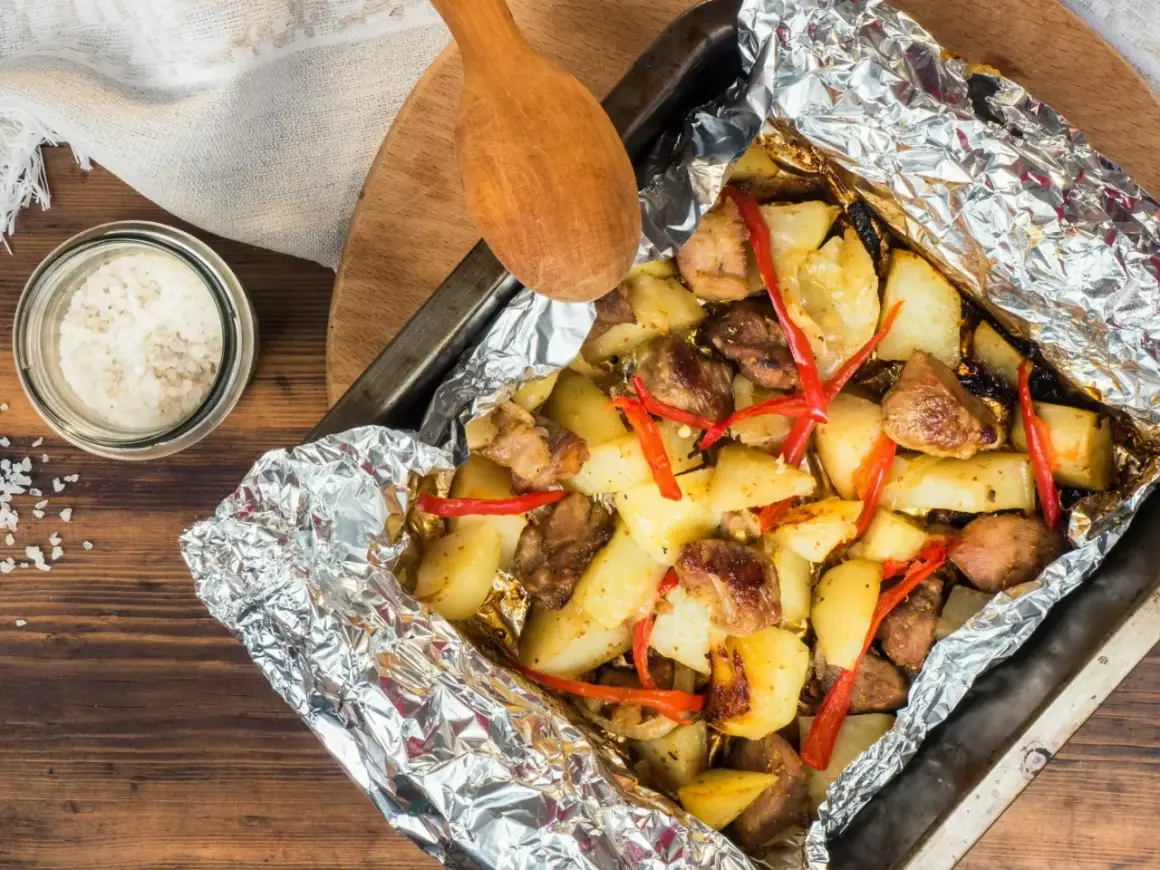 Szybki obiad z piekarnika: pieczone ziemniaki z mięsem i papryczką chili w folii aluminiowej.