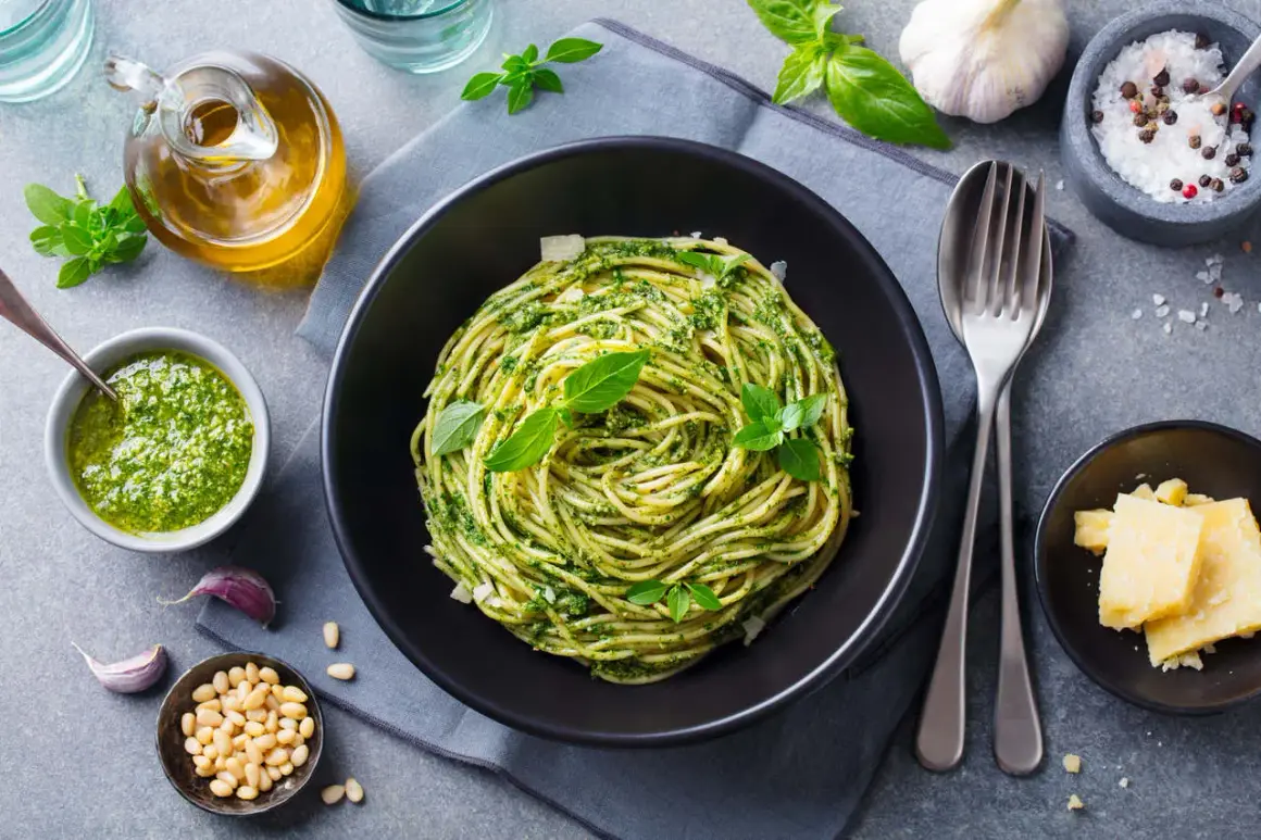 Sycący obiad bez mięsa: spaghetti z pesto, świeżą bazylią, orzeszkami pinii i parmezanem. Idealne danie dla wegetarian.