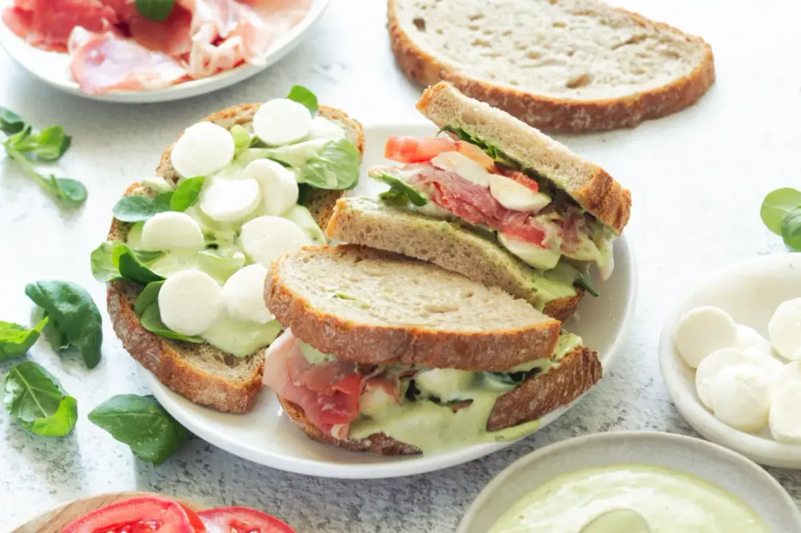 Pyszne włoskie kanapki z mozzarellą, szynką parmeńską i zielonym sosem na chrupiącym pieczywie.