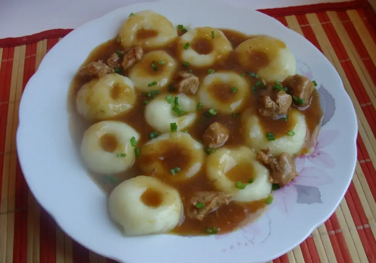 Kluski śląskie z dziurką na talerzu z sosem