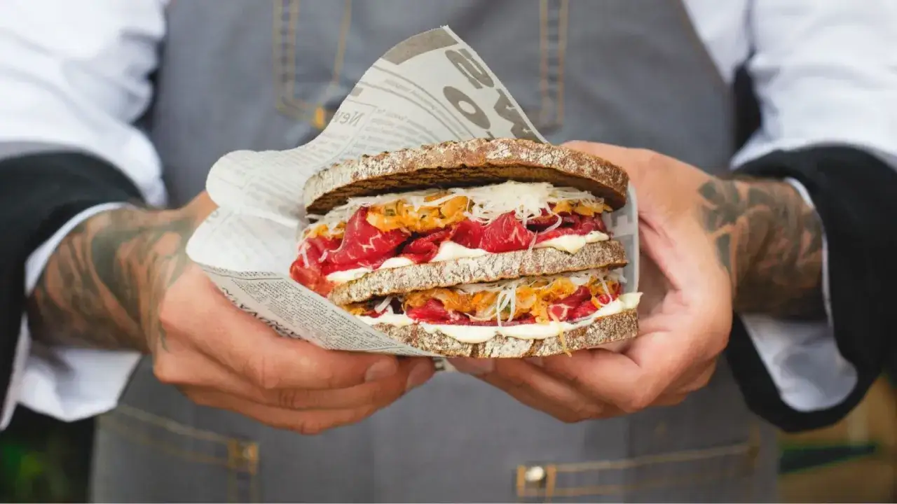 Tajemnicze pastrami co to? Oto kanapka z ciemnego pieczywa, obficie wypełniona plastrami wołowiny, majonezem i surówką.