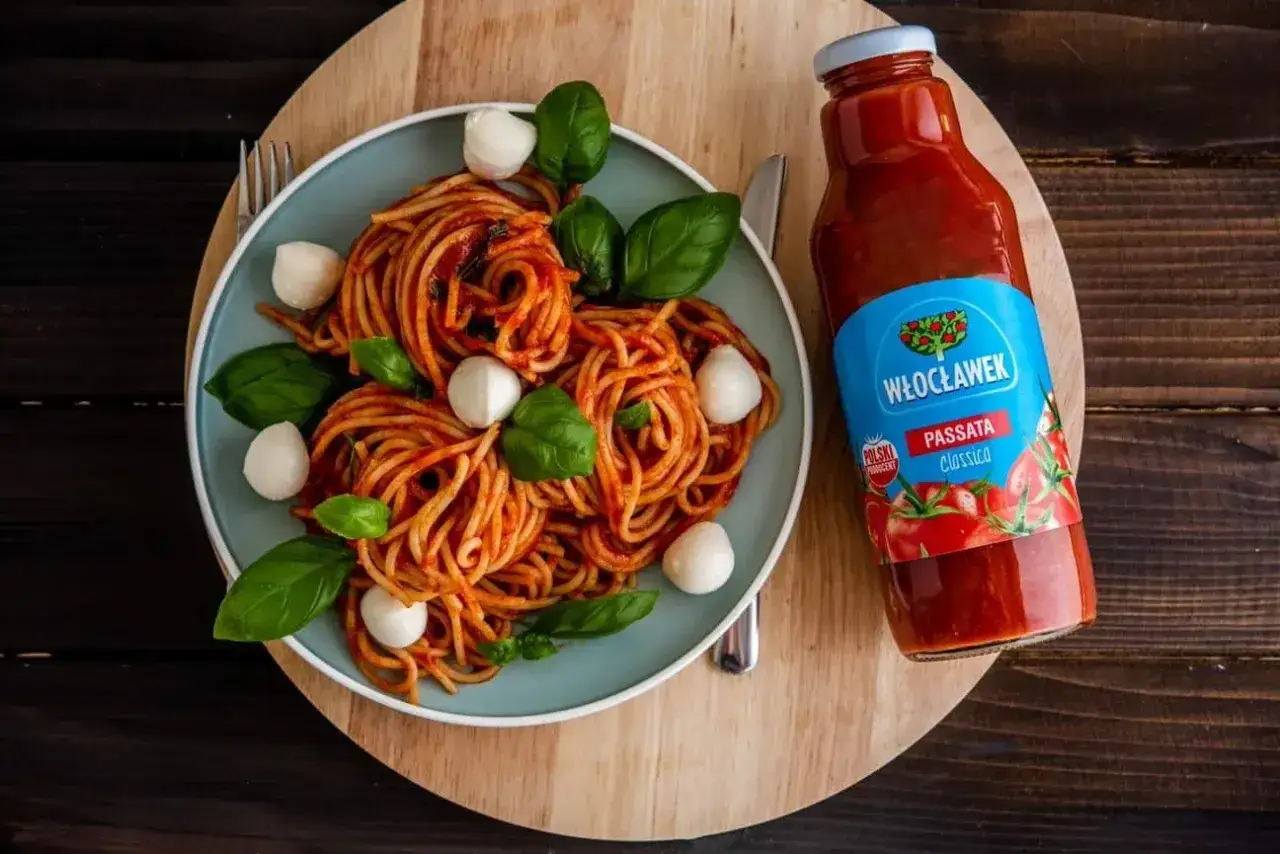 Pyszne spaghetti z kulkami mozzarelli i bazylią, polane sosem z pomidorów Włocławek. Idealna pulpa pomidorowa na włoski obiad.