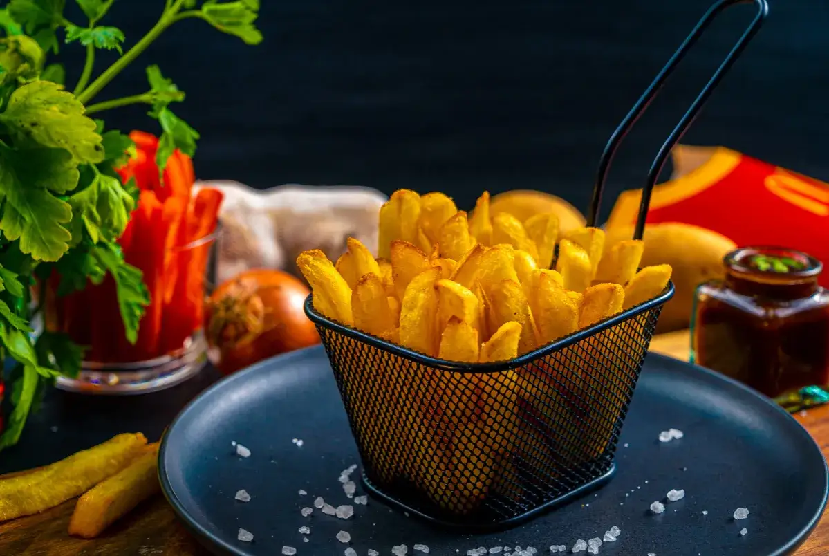 Chrupiące frytki w koszyczku, jak z McDonald's. Obok sos i ziemniaki.