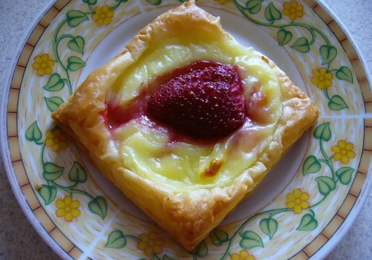 Pyszny deser z ciasta francuskiego z kremem i truskawką. Idealny pomysł, co zrobić z ciasta francuskiego na szybką przekąskę.