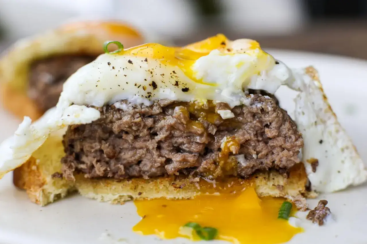 Jak zrobić hamburgera? Soczysty kotlet wołowy, jajko sadzone z płynnym żółtkiem i grzanka. Pyszny pomysł na śniadanie.