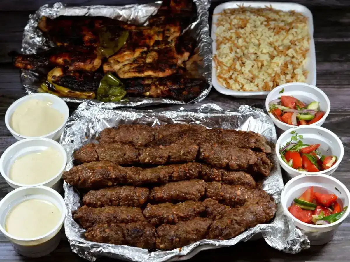 Pyszny kofta kebab z grillowanym kurczakiem, ryżem i sałatkami. Idealny posiłek dla całej rodziny.