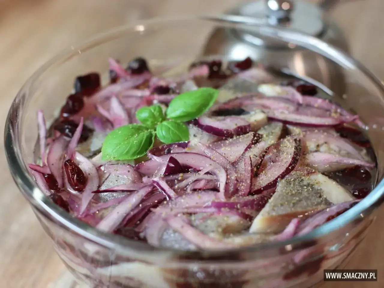 Śledzie w zalewie z aromatyczną, czerwoną cebulą i listkami bazylii.
