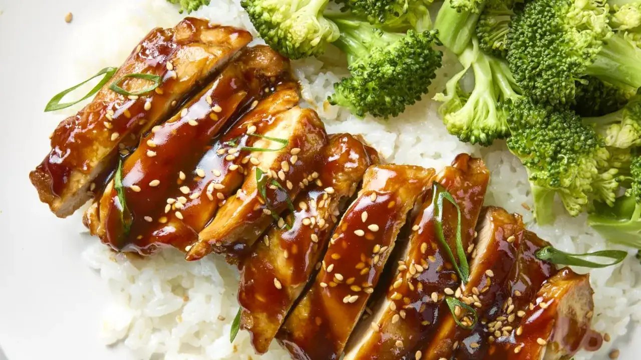 Pyszny kurczak po japońsku w sosie teriyaki, posypany sezamem, podany z ryżem i brokułami.