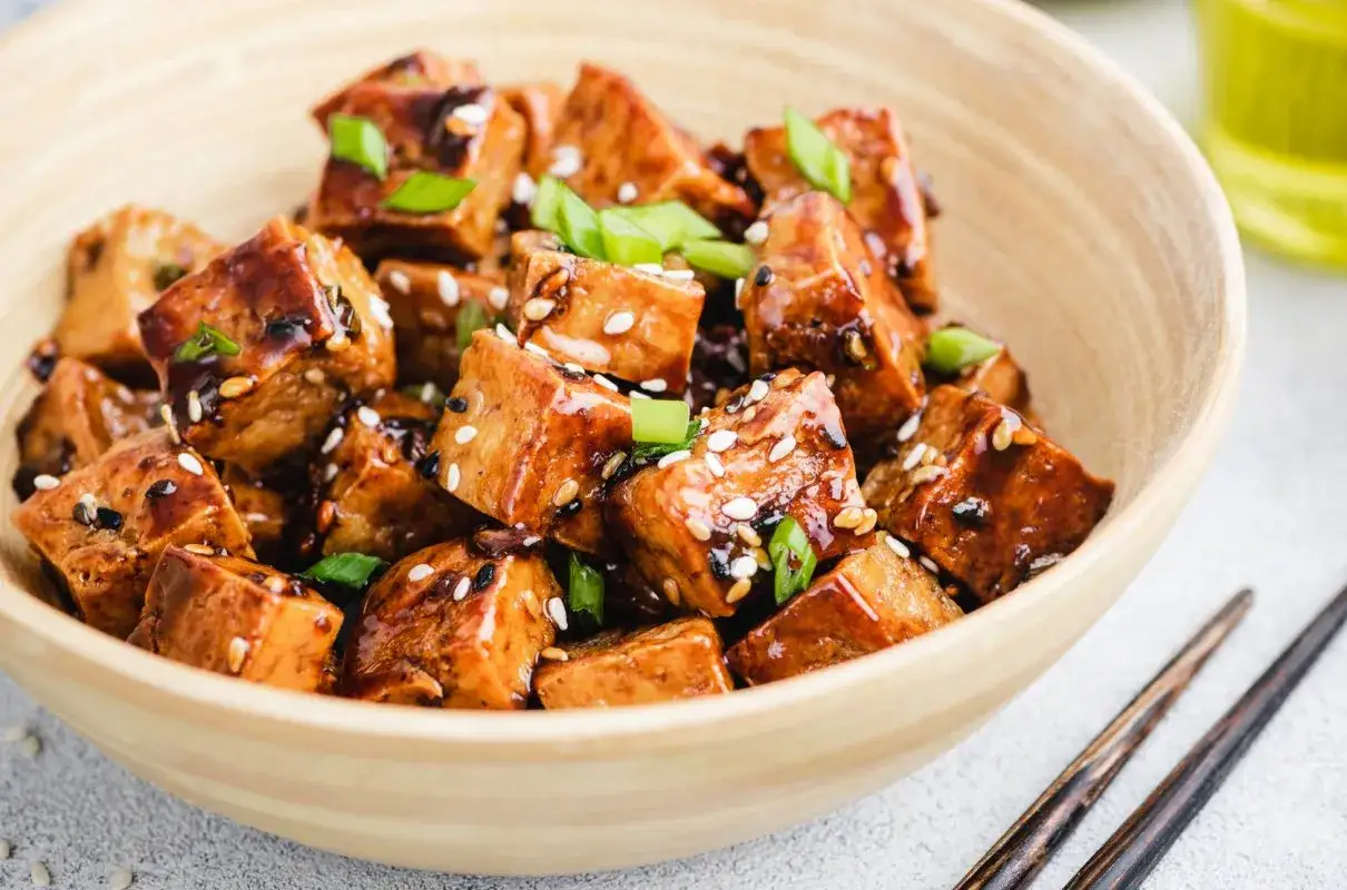Kawałki tofu w sosie teriyaki, posypane sezamem i szczypiorkiem. Idealna marynata do tofu, która nada daniu głębi smaku.